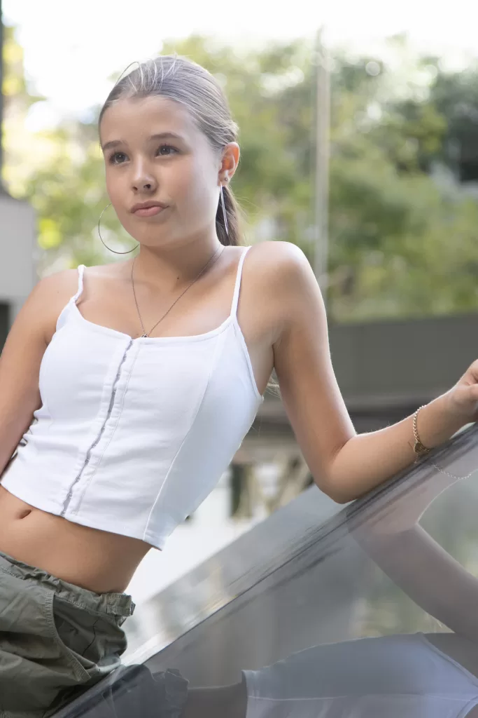 Photo of a blonde teen model wearing a white top